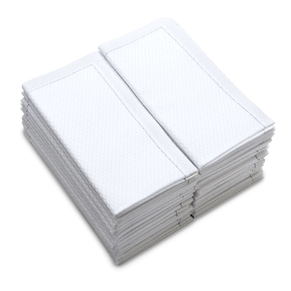 Stack of folded white organic cotton towels with textured pattern