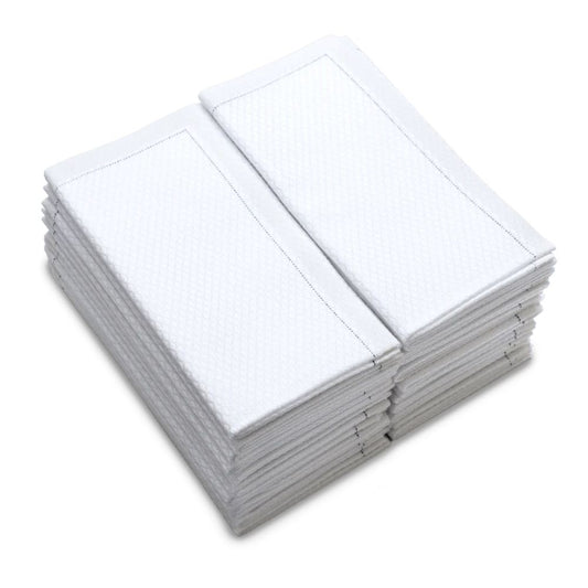 Stack of folded white organic cotton towels with textured pattern