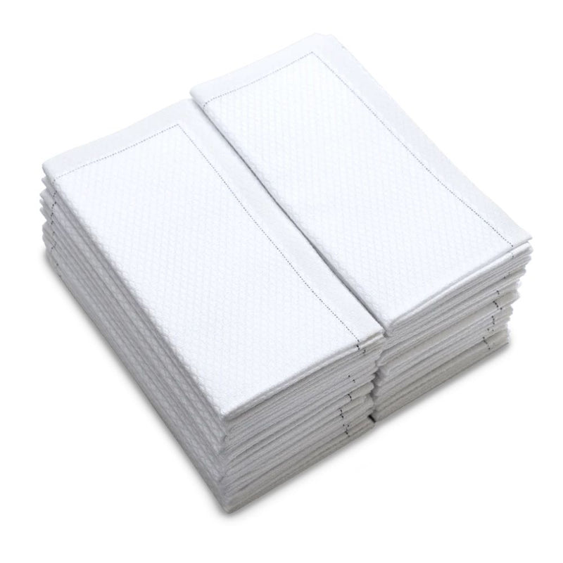 Stack of folded white organic cotton towels with textured pattern