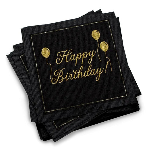 Stack of black organic cotton cocktail napkins with gold “Happy Birthday!” script and balloon design, by Five Star Napkins