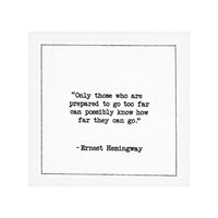 Organic cotton cocktail napkin with black dotted border printed with the quote "Only those who are prepared to go too far can possibly know how far they can go," from Five Star Napkins' Hemingway quote collection
