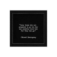 Organic cotton cocktail napkin, black, with white dotted border printed with the quote "Only those who are prepared to go too far can possibly know how far they can go," from Five Star Napkins' Hemingway quote collection