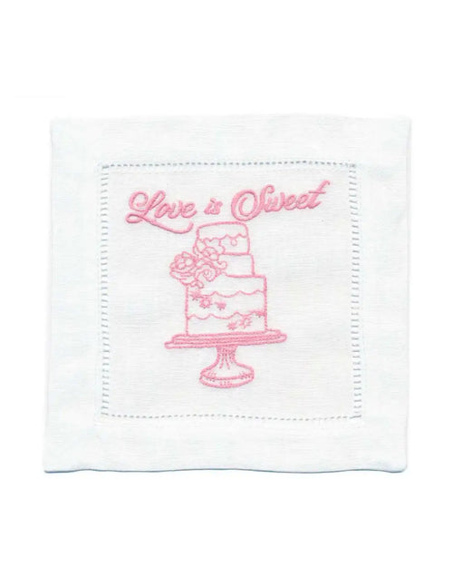 Organic cotton cocktail napkin with pink cake and 'Love is Sweet' quote embroidered