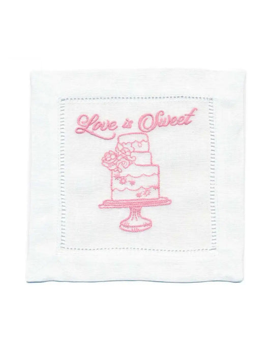 Organic cotton cocktail napkin with pink cake and 'Love is Sweet' quote embroidered