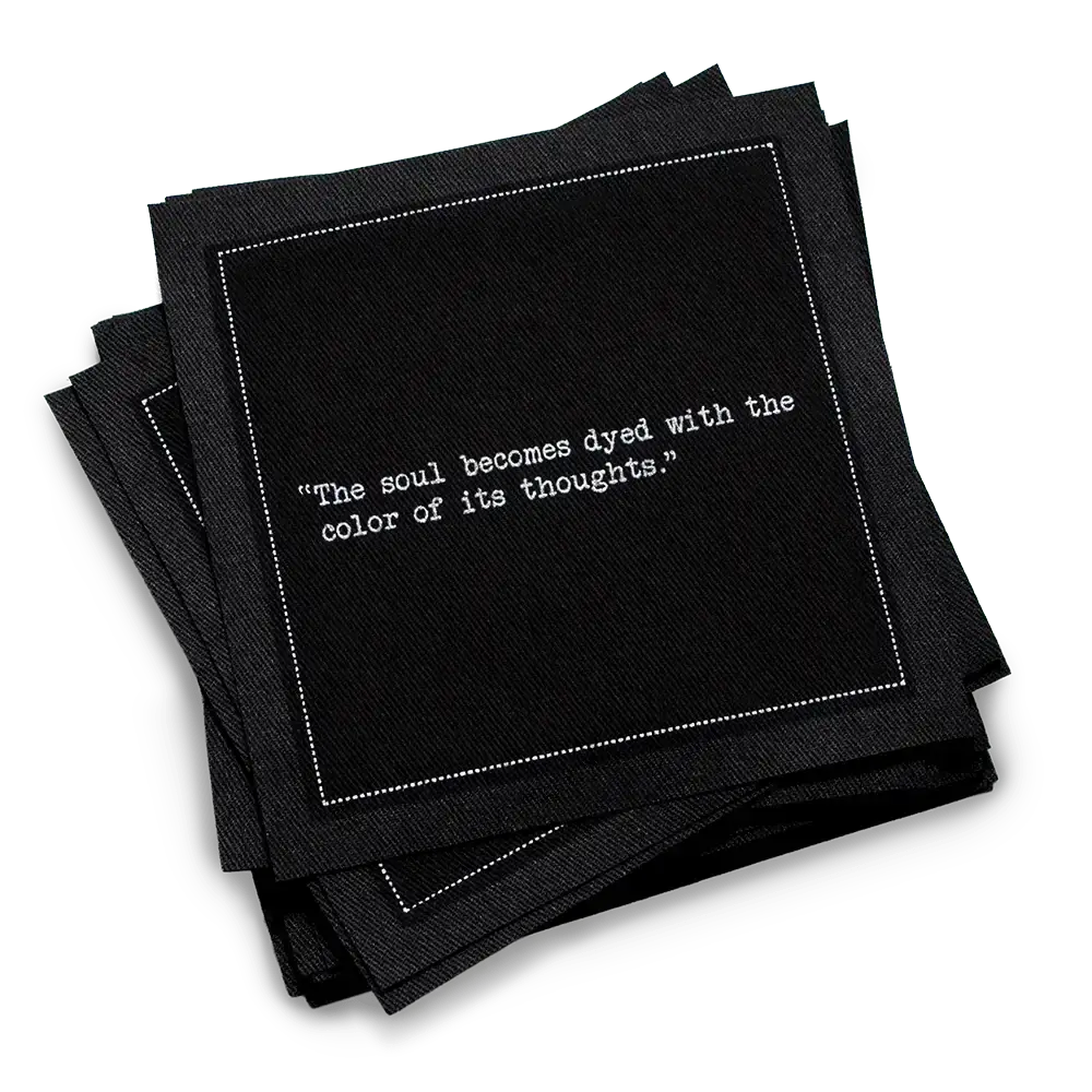 Organic cotton cocktail napkin, black, with white dotted border printed with the quote "The soul becomes dyed with the color of its thoughts," from Five Star Napkins' Marcus Aurelius quote collection
