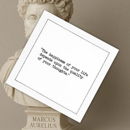 Organic cotton cocktail napkin printed with the quote "The happiness of your life depends upon the quality of your thoughts," styled in front of a marble bust of Marcus Aurelius, from Five Star Napkins' Marcus Aurelius quote collection