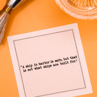 Organic cotton cocktail napkin with quote 'A ship in harbor is safe, but that is not what ships are built for.' on a cocktail party table setting