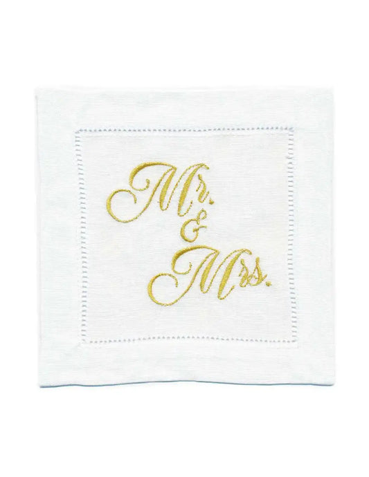 Organic cotton cocktail napkin with hemstitched border, embroidered with “Mr. & Mrs.” in gold script, by Five Star Napkins.