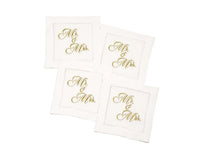 Set of four organic cotton cocktail napkins embroidered with “Mr. & Mrs.” in gold script, by Five Star Napkins.