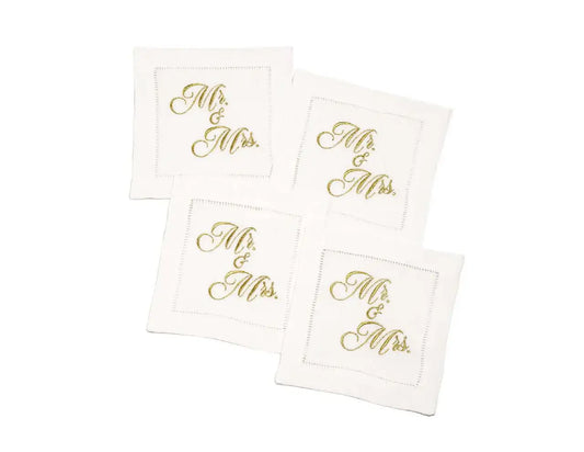 Set of four organic cotton cocktail napkins embroidered with “Mr. & Mrs.” in gold script, by Five Star Napkins.
