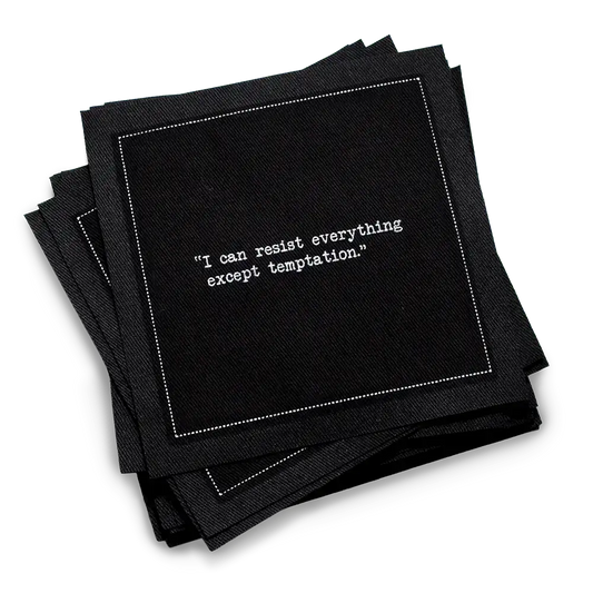 Organic cotton cocktail napkin, black, with white dotted border printed with the quote "I can resist everything except temptation," from Five Star Napkins' Oscar Wilde quote collection