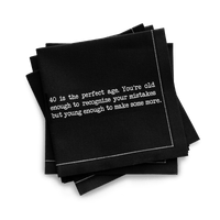 Organic cotton quarter-fold napkin, black, with white dotted border printed with the quote "40 is the perfect age. You're old enough to recognize your mistakes but young enough to make some more," from Five Star Napkins' 40th birthday quote collection