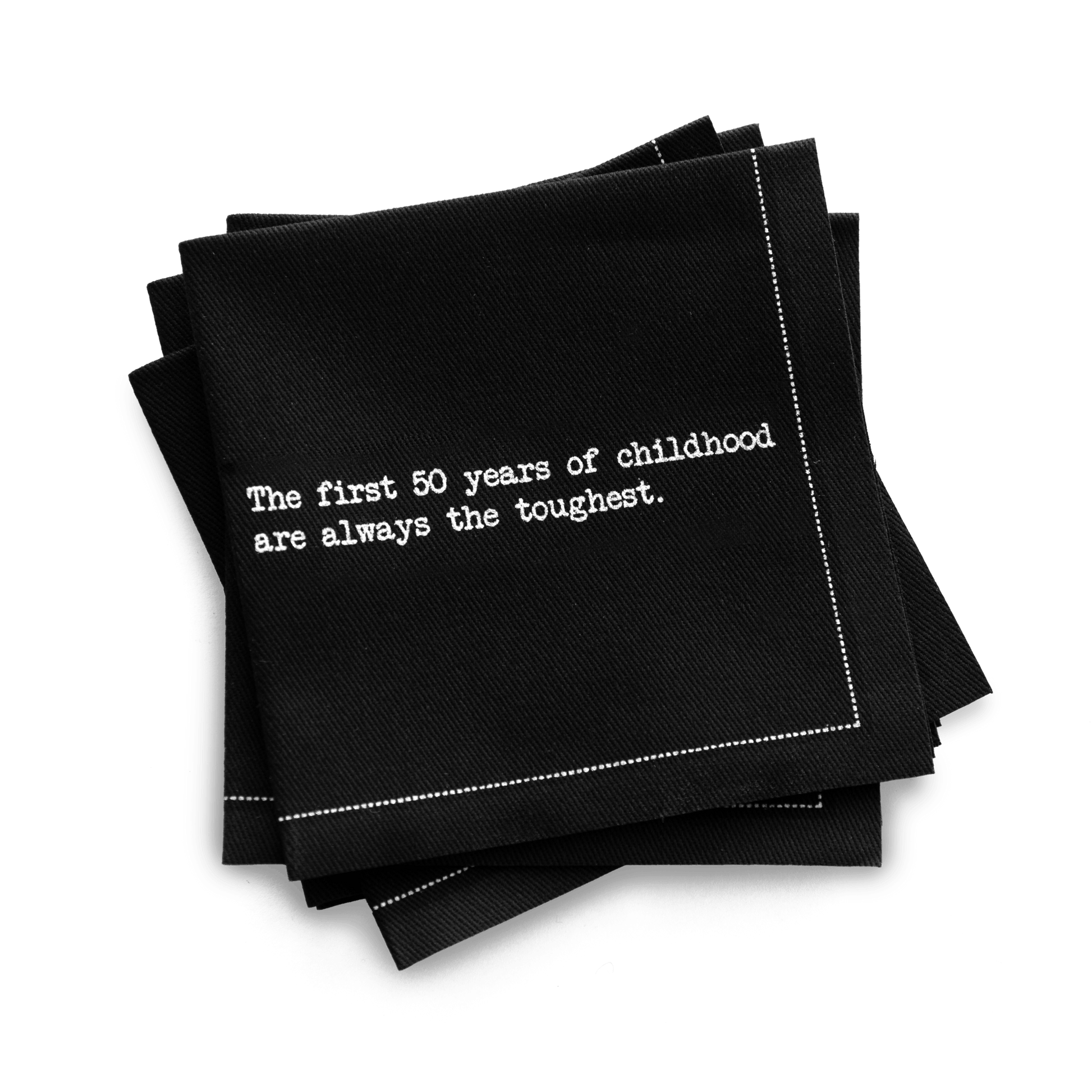 Organic cotton quarter-fold napkin, black, with white dotted border printed with the quote "The first 50 years of childhood are always the toughest," from Five Star Napkins' 50th birthday quote collection