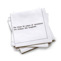 Organic cotton quarter-fold napkin, white, with black dotted border printed with the quote "The first 50 years of childhood are always the toughest," from Five Star Napkins' 50th birthday quote collection