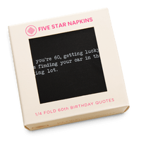 Kraft gift box from Five Star Napkins' 1/4 Fold 60th Birthday Quotes collection, showing an organic cotton quarter-fold napkin, black, printed with the quote "When you're 60, getting lucky means finding your car in the parking lot"