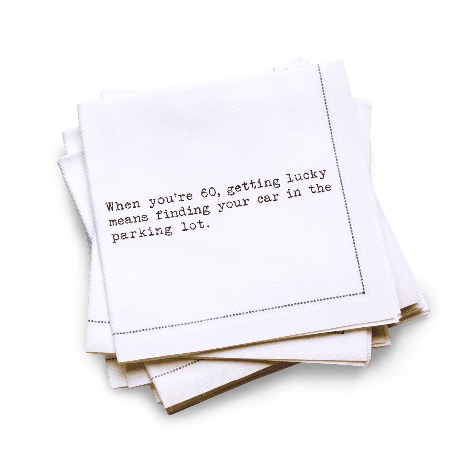 Organic cotton quarter-fold napkin with black dotted border printed with the quote "When you're 60, getting lucky means finding your car in the parking lot," from Five Star Napkins' 60th birthday quote collection