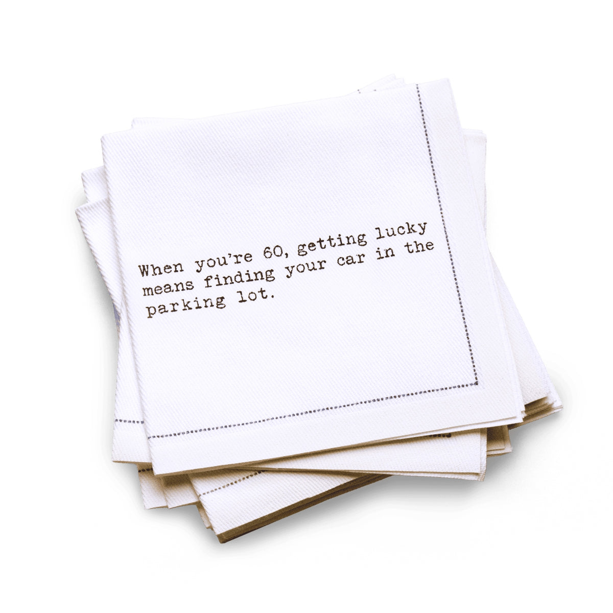 Organic cotton quarter-fold napkin with black dotted border printed with the quote "When you're 60, getting lucky means finding your car in the parking lot," from Five Star Napkins' 60th birthday quote collection