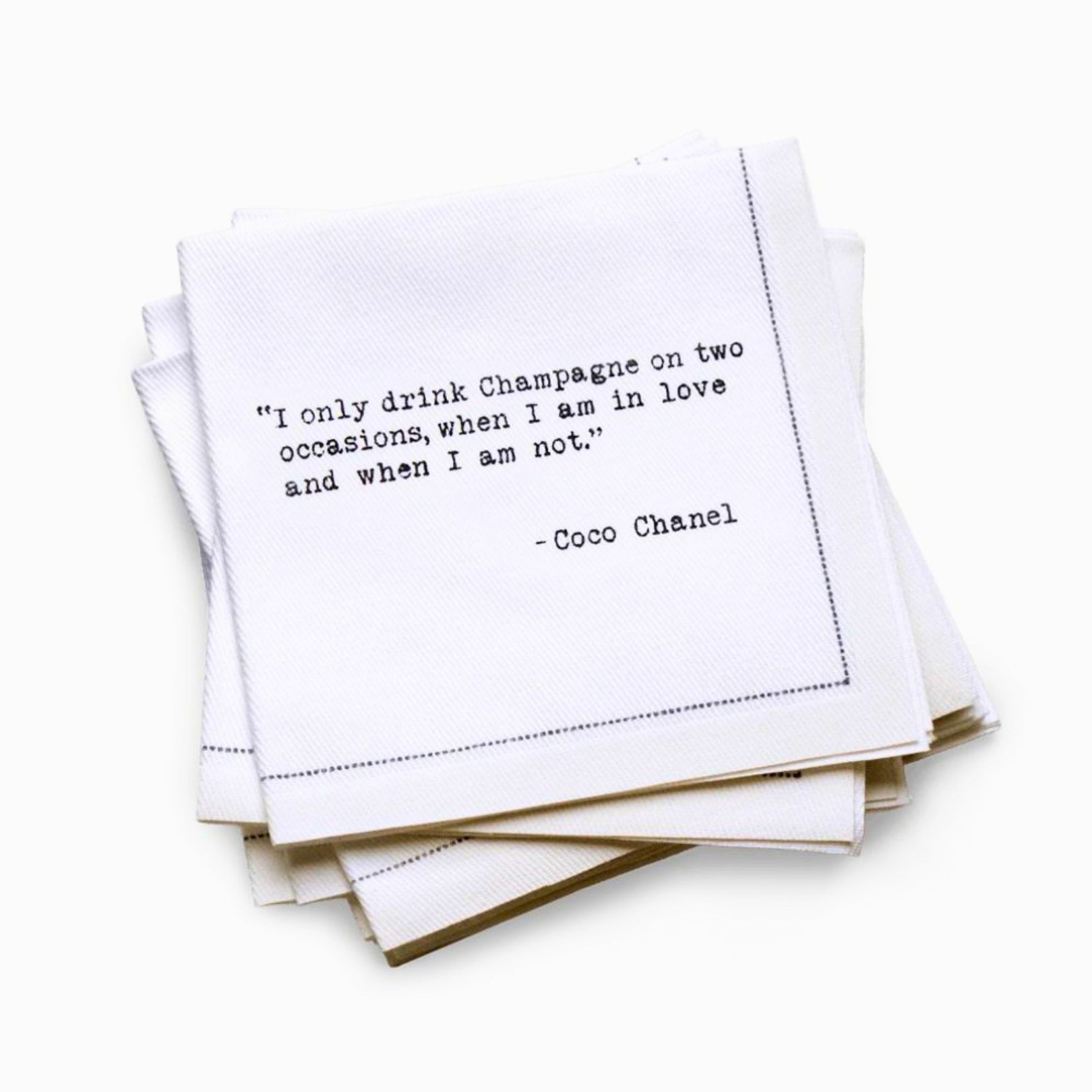 Quarter-fold organic cotton cocktail napkin with black dotted border printed with the Coco Chanel quote "I only drink Champagne on two occasions, when I am in love and when I am not," from Five Star Napkins' Champagne quote collection