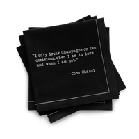Quarter-fold organic cotton cocktail napkin, black, with white dotted border printed with the Coco Chanel quote "I only drink Champagne on two occasions, when I am in love and when I am not," from Five Star Napkins' Champagne quote collection