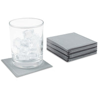 Stack of Anthracite Grey organic cotton cocktail napkins, 1/4 fold, beside a glass with ice