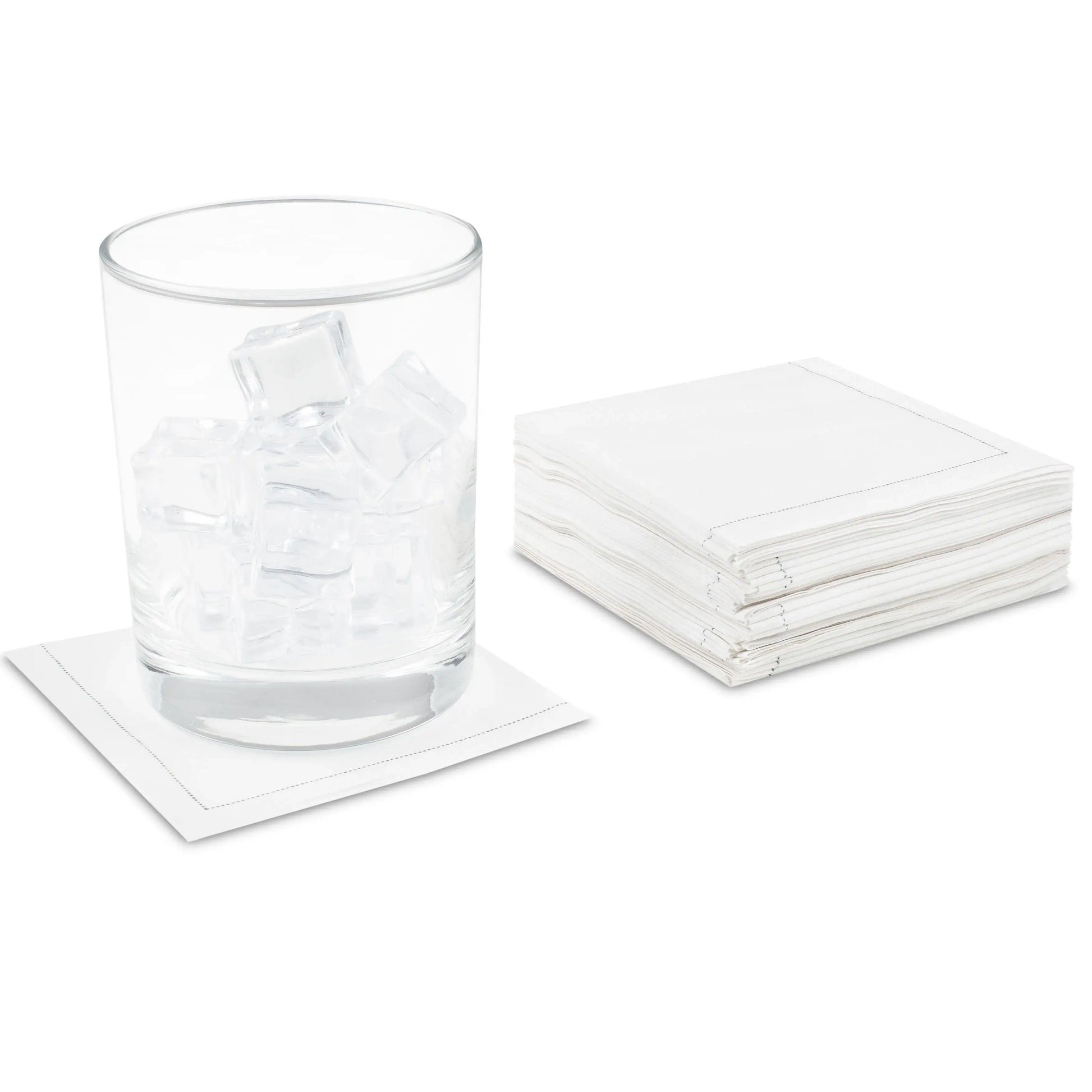 Stack of white organic cotton cocktail napkins, one under a glass with ice