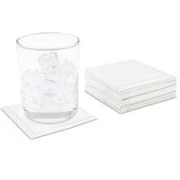 Stack of white organic cotton cocktail napkins, one under a glass with ice