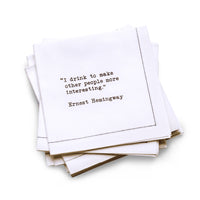 Quarter-fold organic cotton cocktail napkin with black dotted border printed with the quote "I drink to make other people more interesting," from Five Star Napkins' Drinking Quotes First Edition collection