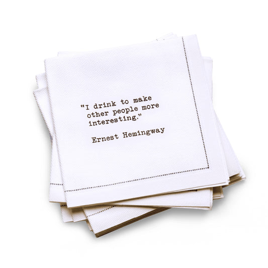 Quarter-fold organic cotton cocktail napkin with black dotted border printed with the quote "I drink to make other people more interesting," from Five Star Napkins' Drinking Quotes First Edition collection