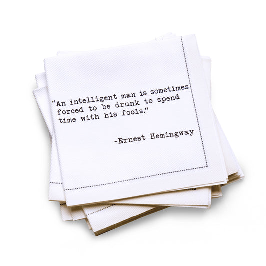 Organic cotton quarter-fold napkin printed with the quote "An intelligent man is sometimes forced to be drunk to spend time with his fools," from Five Star Napkins' Drinking Quotes Second Edition collection