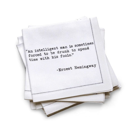 Stack of white napkins with black text quote by Ernest Hemingway on a white background