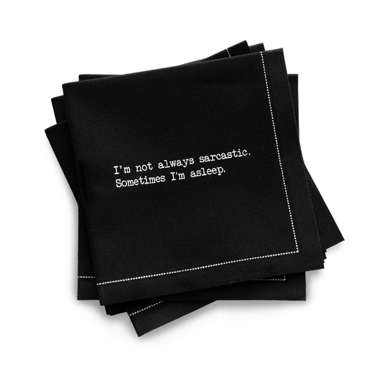 Quarter-fold organic cotton cocktail napkin, black, with white dotted border printed with the quote "I'm not always sarcastic. Sometimes I'm asleep," from Five Star Napkins' Snarky quote collection