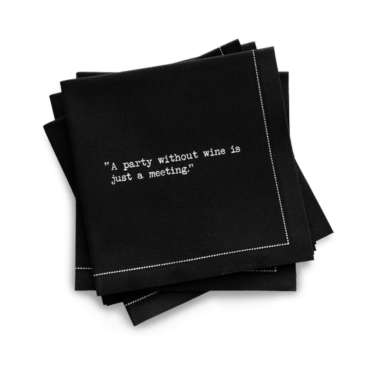 Quarter-fold organic cotton cocktail napkin, black, with white dotted border printed with the quote "A party without wine is just a meeting," from Five Star Napkins' Wine quote collection