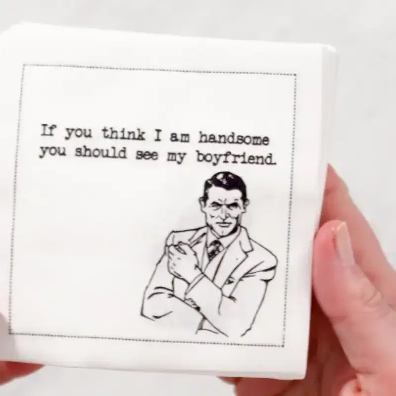 Video close-up of an organic cotton cocktail napkin printed with the quote “If you think I am handsome, you should see my boyfriend,” paired with a retro cartoon illustration, from Five Star Napkins’ Rainbow Cartoons quote collection.
