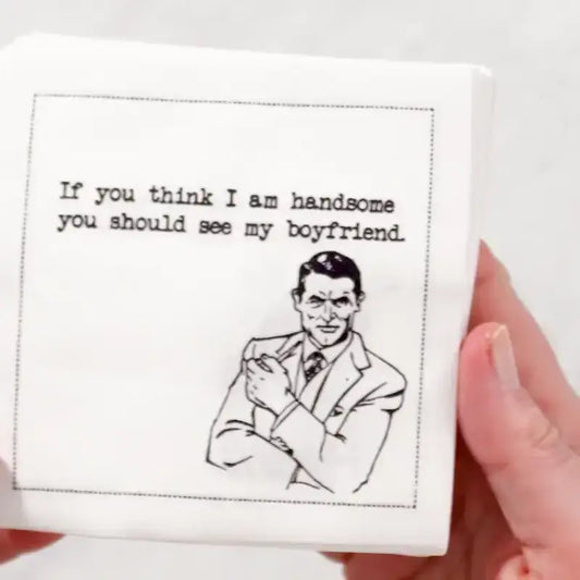 Video close-up of an organic cotton cocktail napkin printed with the quote “If you think I am handsome, you should see my boyfriend,” paired with a retro cartoon illustration, from Five Star Napkins’ Rainbow Cartoons quote collection.