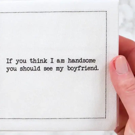 Video close-up of an organic cotton cocktail napkin printed with the quote “If you think I am handsome, you should see my boyfriend,” paired with a retro cartoon illustration, from Five Star Napkins’ Rainbow quote collection.