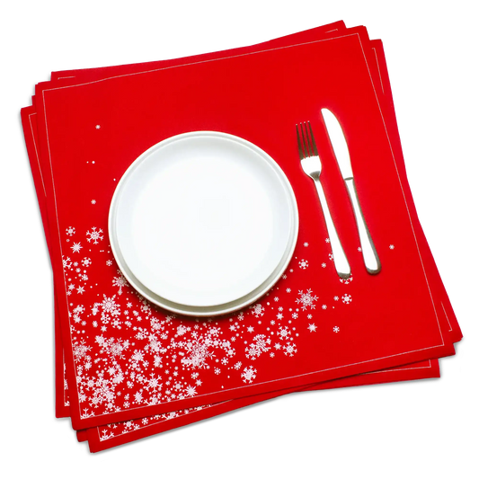Red organic cotton dinner napkin with white snowflake cascade pattern, set beneath a plate and silverware, by Five Star Napkins.