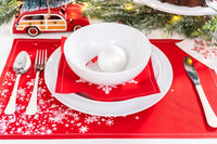 Red organic cotton placemat and napkin with white snowflake pattern on holiday table setting