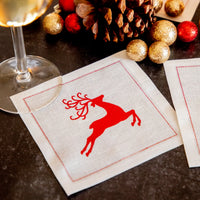 organic cotton cocktail napkin with red reindeer design in holiday table setting