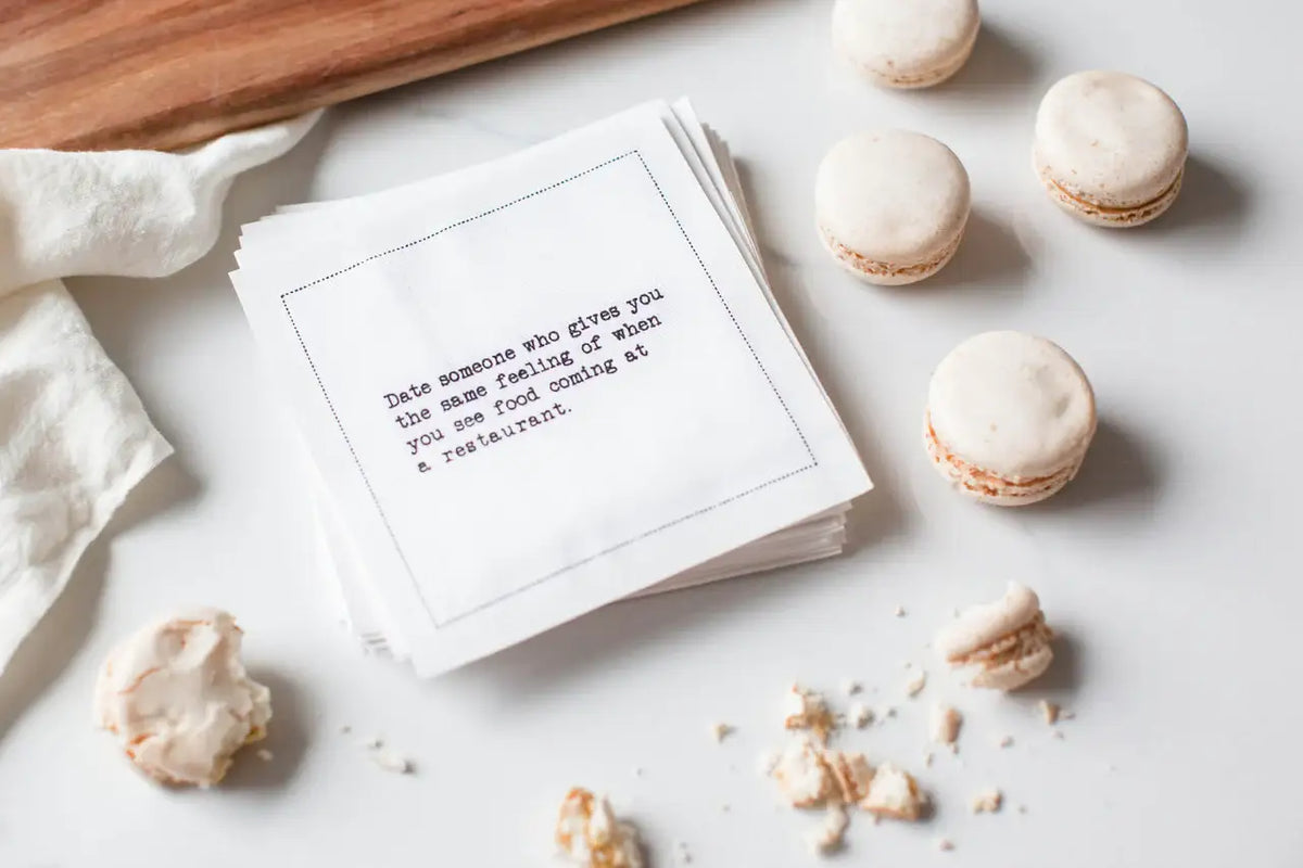 Organic cotton quote napkin with printed text and macarons on a table setting