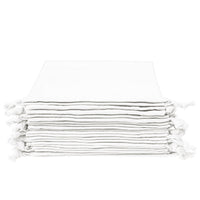 Stack of white organic cotton napkins with knotted tassel corners