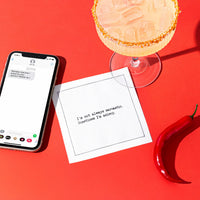 Organic cotton cocktail napkin printed with the quote "I'm not always sarcastic. Sometimes I'm asleep," styled on a red background with a margarita, a phone, and a chili pepper, from Five Star Napkins' Snarky quote collection