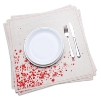 Natural organic cotton dinner napkins with a red snowflake print, dressed on a plate with silverware, by Five Star Napkins.