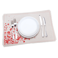 Luxury organic cotton placemat with red star design, set with plates and silverware