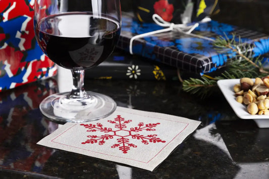 organic cotton napkin with red snowflake design under wine glass on a cocktail party table setting