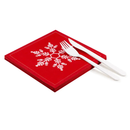 Stack of red organic cotton napkins in Toreador with white snowflake design and white cutlery