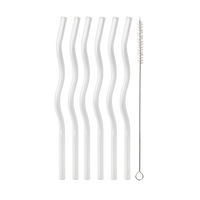 Six clear, reusable curved straws and a cleaning brush on black background