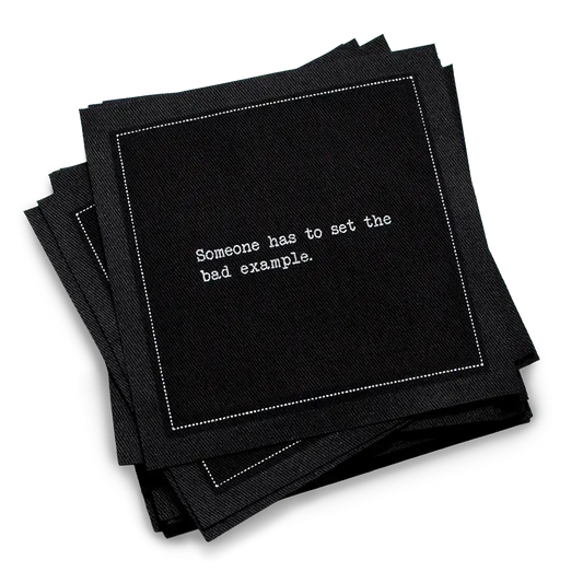 Organic cotton cocktail napkin, black, with white dotted border printed with the quote "Someone has to set the bad example," from Five Star Napkins' Subversive quote collection