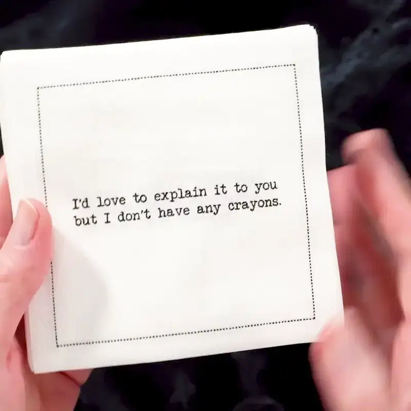 Video of a hand holding an organic cotton cocktail napkin printed with the quote "I'd love to explain it to you but I don't have any crayons," from Five Star Napkins' Subversive quote collection