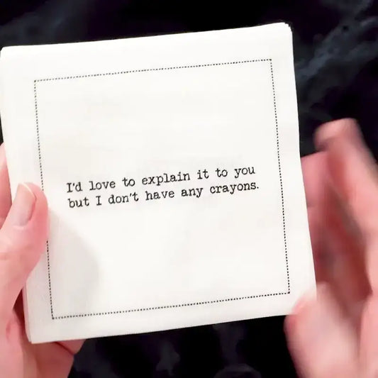 Video of a hand holding an organic cotton cocktail napkin printed with the quote "I'd love to explain it to you but I don't have any crayons," from Five Star Napkins' Subversive quote collection