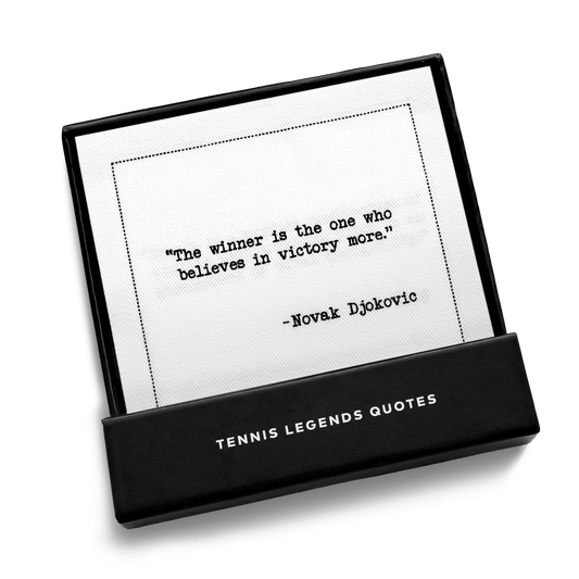 Close-up of an open Five Star Napkins Tennis Legends Quotes gift box, showing a cocktail napkin printed with the quote “The winner is the one who believes in victory more,” – Novak Djokovic.